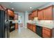 Modern kitchen with wood cabinets, black appliances, and tile floors at 305 Mogie Ln, Acworth, GA 30102