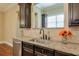 Kitchen features granite countertops, a farmhouse sink, and dark cabinetry at 2005 Heathermere Way, Roswell, GA 30075
