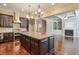 Kitchen boasts granite island, stainless steel appliances, and dark cabinetry at 2005 Heathermere Way, Roswell, GA 30075