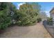 Lawn area with landscaping features mature trees and a black metal fence at 2935 Maple Park Pl # 49, Cumming, GA 30041