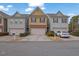 View of townhomes with attached garages, landscaped bushes, and driveways on a cloudy day at 2935 Maple Park Pl # 49, Cumming, GA 30041