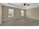 Large main bedroom with carpet, tray ceilings, and two windows at 2935 Maple Park Pl # 49, Cumming, GA 30041