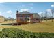 Back exterior view of the brick home with deck and expansive yard at 328 Thistlewood Run, Mcdonough, GA 30252