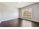 Bedroom with hardwood floors, white trim, and a bright window at 328 Thistlewood Run, Mcdonough, GA 30252