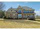 Traditional brick home with manicured front lawn and inviting covered porch, perfect for a growing Gathering at 328 Thistlewood Run, Mcdonough, GA 30252