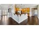 Well-lit kitchen featuring an island with granite countertop and dark hardwood floors at 328 Thistlewood Run, Mcdonough, GA 30252