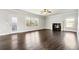 Open living room with fireplace, hardwood floors, large windows, and a glass door at 328 Thistlewood Run, Mcdonough, GA 30252