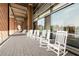 Inviting covered porch with a row of classic white rocking chairs along a brick-accented walkway at 879 Perennial Dr, Sandy Springs, GA 30328