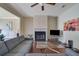 Inviting living room with fireplace, modern ceiling fan, wood floors, and gray sectional sofa at 2725 Morgan Glen Rd, Buford, GA 30519