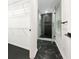 The entrance of a modern bathroom with a glass shower, dark floors, and shelving at 2704 Ellen Way, Decatur, GA 30032