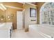 Inviting bathroom featuring a soaking tub under a large window and double vanity at 1150 Cedar Bluff Sw Trl, Lilburn, GA 30047