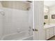 Bathroom showcasing a tub-shower combo and white tile, adjacent to a vanity area with a framed mirror at 1150 Cedar Bluff Sw Trl, Lilburn, GA 30047