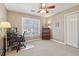 Carpeted bedroom features a ceiling fan and a bright window that allows for natural lighting at 1150 Cedar Bluff Sw Trl, Lilburn, GA 30047