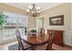 Elegant dining room with hardwood floors, a wooden table, and a stylish chandelier at 1150 Cedar Bluff Sw Trl, Lilburn, GA 30047