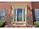 Close-up of the front door with sidelights, detailed trim, and wrought iron railing at 1150 Cedar Bluff Sw Trl, Lilburn, GA 30047