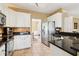 Well-lit kitchen featuring granite counters, stainless steel appliances, tile flooring, and white cabinetry at 1150 Cedar Bluff Sw Trl, Lilburn, GA 30047