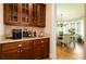 Butlers pantry with glass-front cabinets, granite countertops, and wine storage at 260 Koller Dr, Powder Springs, GA 30127