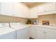 Laundry room with white cabinets, washer, dryer, and utility sink at 260 Koller Dr, Powder Springs, GA 30127
