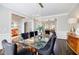 Formal dining room features a glass table, black chairs, modern chandelier, and wainscotting at 510 Newport Trce, Alpharetta, GA 30005