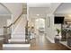 Hardwood foyer and staircase with decorative iron spindles leading to the living room at 6860 Crofton Dr, Alpharetta, GA 30005