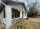 Classic bungalow showcasing the charming front porch with white columns, dark trim, and siding at 1790 Spring Ave, East Point, GA 30344