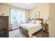 Cozy bedroom features a wood bed frame, colorful rug and natural light from a window at 6615 Hampton Rock Ln, Cumming, GA 30041