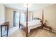 This is a primary bedroom with a four post bed and windows with a curtain at 6615 Hampton Rock Ln, Cumming, GA 30041