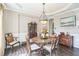 Elegant dining room featuring hardwood floors, wainscoting, stylish chandelier, and decorative furnishings at 6615 Hampton Rock Ln, Cumming, GA 30041
