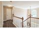 Hallway with wooden floors, white railings, crown molding and a hanging chandelier at 6615 Hampton Rock Ln, Cumming, GA 30041