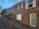 Two-story brick house exterior featuring windows with white shutters and a ground-level door at 8587 Cumming Hwy, Canton, GA 30115