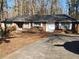 Brick ranch house with attached garage and mature trees at 8587 Cumming Hwy, Canton, GA 30115