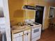 Vintage kitchen features a white stove, outdated countertops, and yellow-painted walls at 8587 Cumming Hwy, Canton, GA 30115