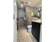 Modern bathroom with a glass enclosed shower, beautiful gray tile, and a dark vanity at 220 Renaissance Pkwy # 1203, Atlanta, GA 30308