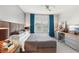 Comfortable bedroom with desk, TV, large windows with blue curtains, gray bedding, and a ceiling fan at 220 Renaissance Pkwy # 1203, Atlanta, GA 30308