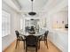 Elegant dining room with modern lighting, mirrored wall, and an open view to the kitchen at 220 Renaissance Pkwy # 1203, Atlanta, GA 30308
