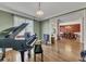 Elegant living room featuring a grand piano and an open doorway to the dining room at 3641 Carriage Glen Way, Dacula, GA 30019