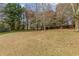 Large backyard with a mix of lawn and wooded area, offering privacy and natural beauty at 5515 Hancock Ln, Cumming, GA 30041