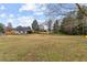 Expansive backyard featuring a new wooden fence, mature trees, swing and a view of the home's exterior at 5515 Hancock Ln, Cumming, GA 30041