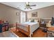 Cozy bedroom featuring a wood bed frame, ceiling fan, and natural light from the window at 5515 Hancock Ln, Cumming, GA 30041