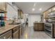 Open kitchen with granite countertops, stainless steel appliances, and tile flooring throughout at 5515 Hancock Ln, Cumming, GA 30041