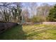 Large, grassy backyard with a wooden fence, featuring play set, perfect for outdoor activities at 1469 Harmony Grove Church Rd, Auburn, GA 30011