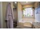 Calm bathroom featuring a soaking tub, granite countertops, and hanging plants at 1469 Harmony Grove Church Rd, Auburn, GA 30011