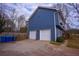 Charming two-car garage on the side of a blue home with new garage doors at 1469 Harmony Grove Church Rd, Auburn, GA 30011