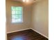 Simple bedroom with dark wood floors and window at 158 Scarsdale Dr, Riverdale, GA 30274