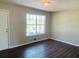 Spacious living room with large window and dark laminate floors at 158 Scarsdale Dr, Riverdale, GA 30274