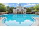 Community pool with crystal blue water reflecting the clubhouse and sky, surrounded by well-maintained landscaping at 8140 High Hampton Chase, Alpharetta, GA 30022