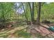 Secluded backyard featuring mature trees, seating and a charming creek at 959 Cedar Falls Sw Ct, Lilburn, GA 30047