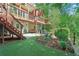 Multi-level backyard featuring lush landscaping, a patio area, and tiered decking at 959 Cedar Falls Sw Ct, Lilburn, GA 30047