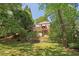 View of the home from the backyard, showing lush greenery and multiple levels of deck at 959 Cedar Falls Sw Ct, Lilburn, GA 30047