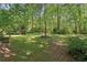 Expansive backyard featuring mature trees and lush landscaping offers privacy and a natural setting at 959 Cedar Falls Sw Ct, Lilburn, GA 30047